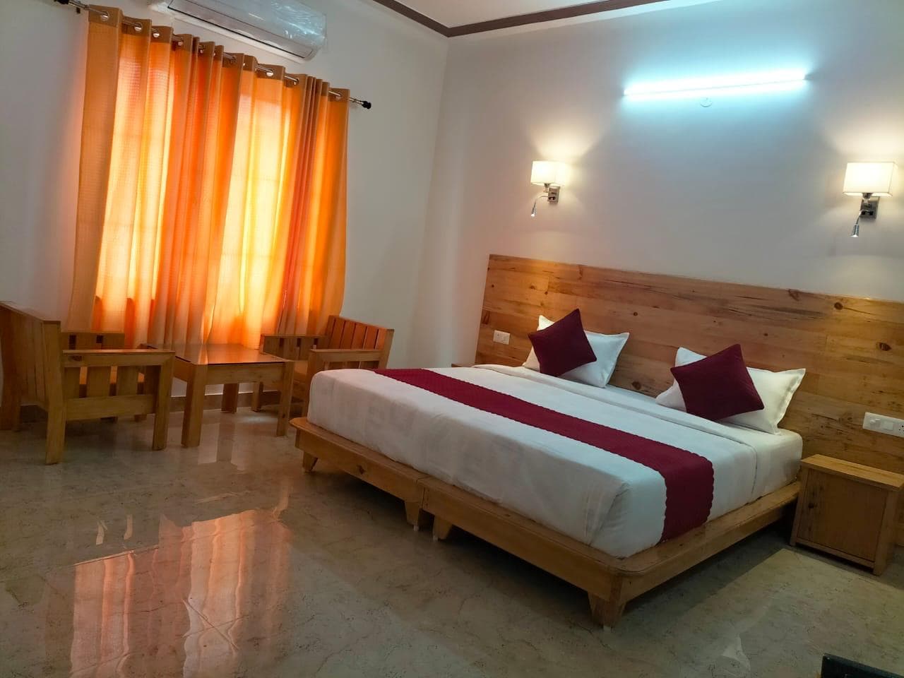 Retreat room with a double bed, wooden headboard and orange curtains