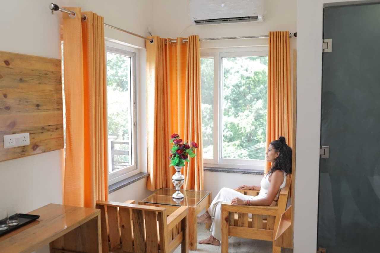 A guest reading by the window in the sitting area of a retreat room