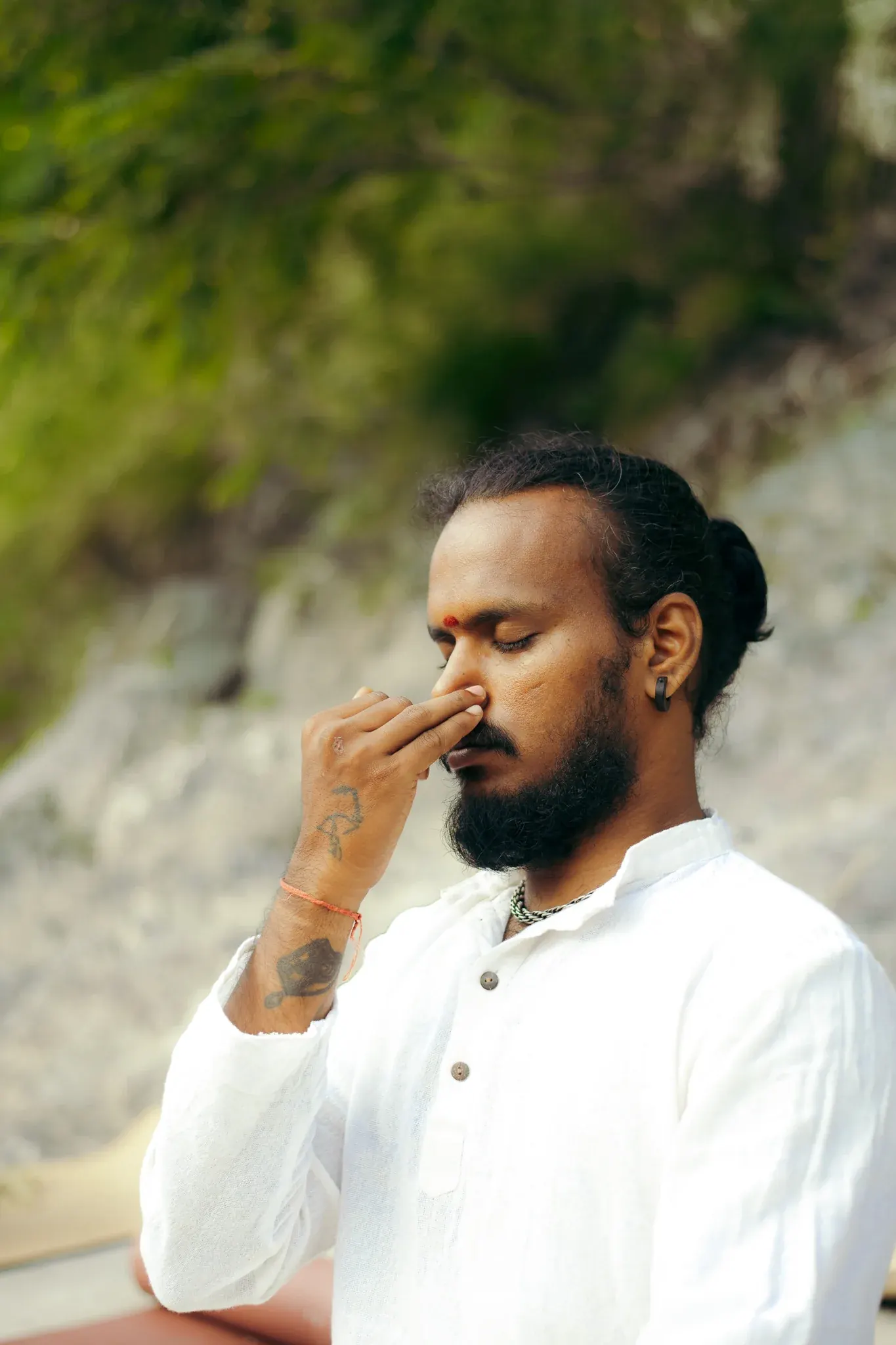 Close-up of a student practising Nadi Shodhana alternate nostril breathing with eyes closed in Rishikesh