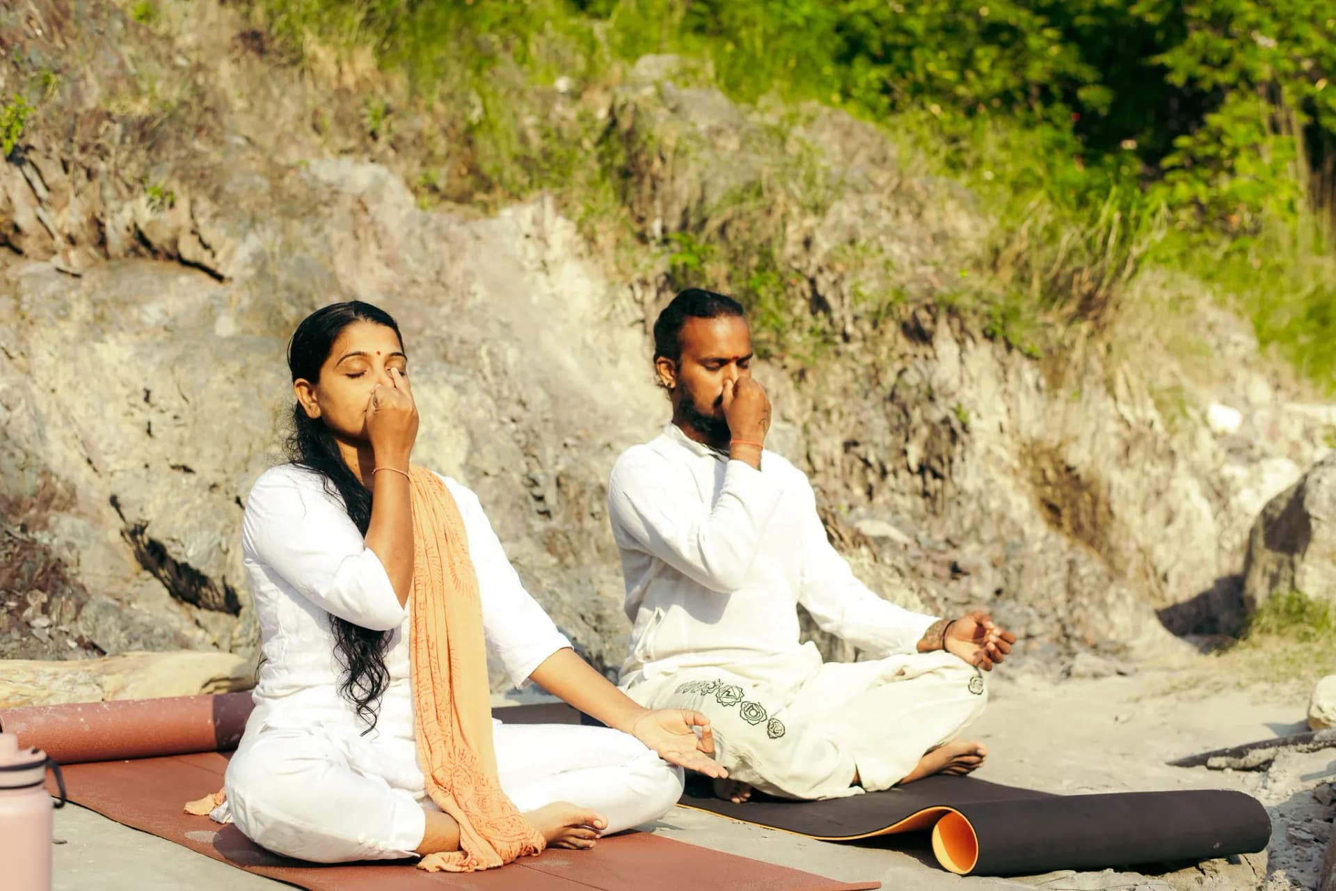 Two students practise Nadi Shodhana with right hand at the nose and left hand in chin mudra in Rishikesh